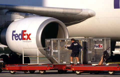 hombres moviendo contenedores LD3 en carros con motor CF6-80 de un carguero FedEx Airbus A300-600 hombres moviendo contenedores LD3 en carros con motor CF6-80 de un carguero FedEx Airbus A300-600
