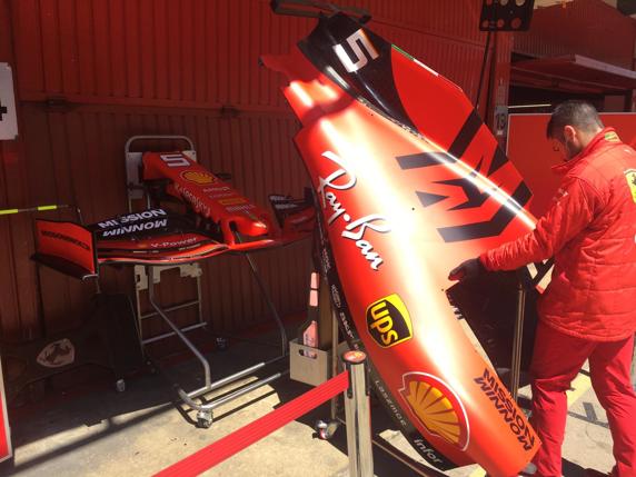 Un mecánico de Ferrari, con una tapa motor y alerones delanteros