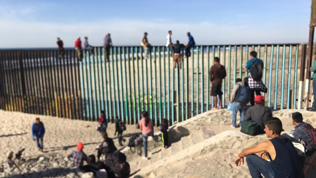 Migrantes trepan la valla que divide a México de EEUU