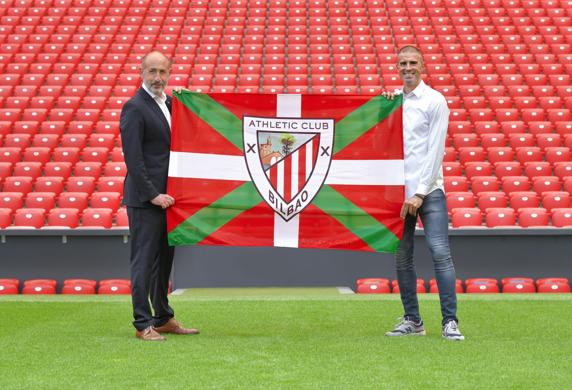 Gaizka Garitano y Aitor Elizegi sujetan una ikurriña con el escudo del Athletic