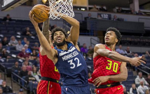 Karl-Anthony Towns penetra a canasta ante la defensa de John Collins en un encuentro de esta temporada.