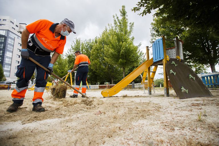 Operarios del Ayuntamiento de Santiago, este lunes en un parque infantil.