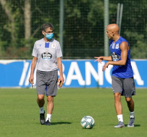 El entrenador del Deportivo de La Coruña, Fernando Vázquez (i) conversa con el delantero Víctor Mollejo (d) durante el entrenamiento del equipo en la ciudad deportiva de Abegondo, A Coruña este jueves.