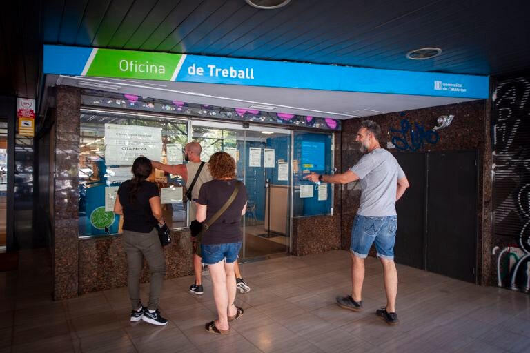 Varias personas a la entrada de una oficina de empleo en Barcelona.