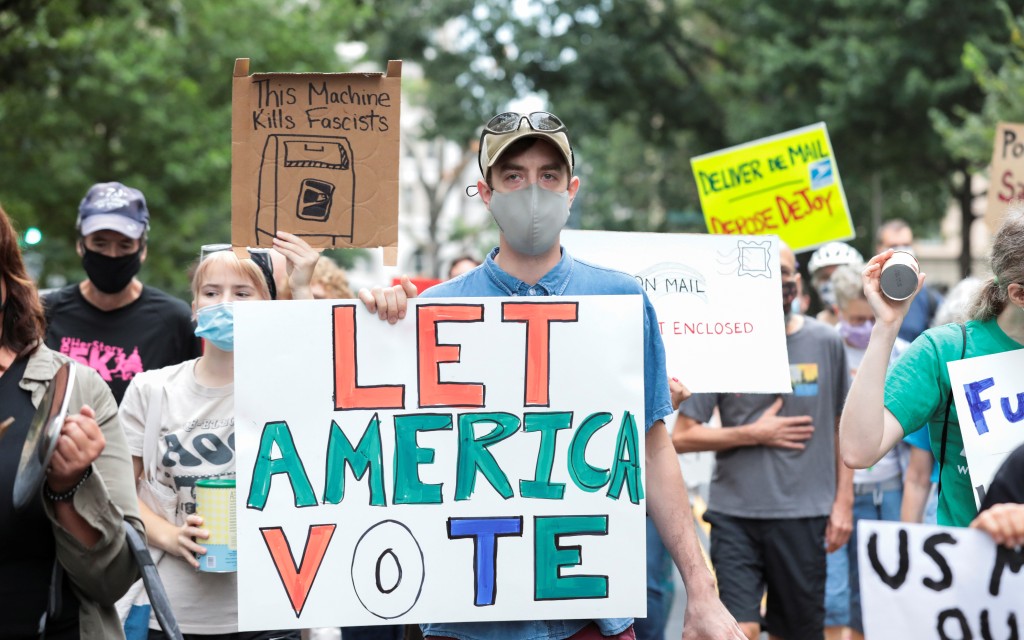 Manifestantes lanzan ‘llamada de atención’ a Director General de Correos de EU | Video