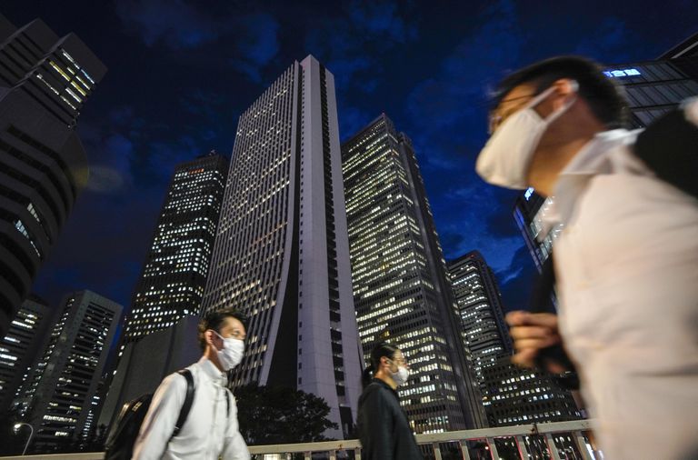 Varias personas caminan por el distrito financiero de Tokio.