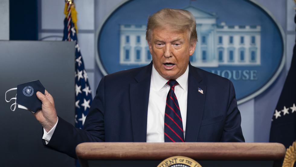 Donald Trump muestra una mascarilla durante una rueda de prensa en la Casa Blanca.