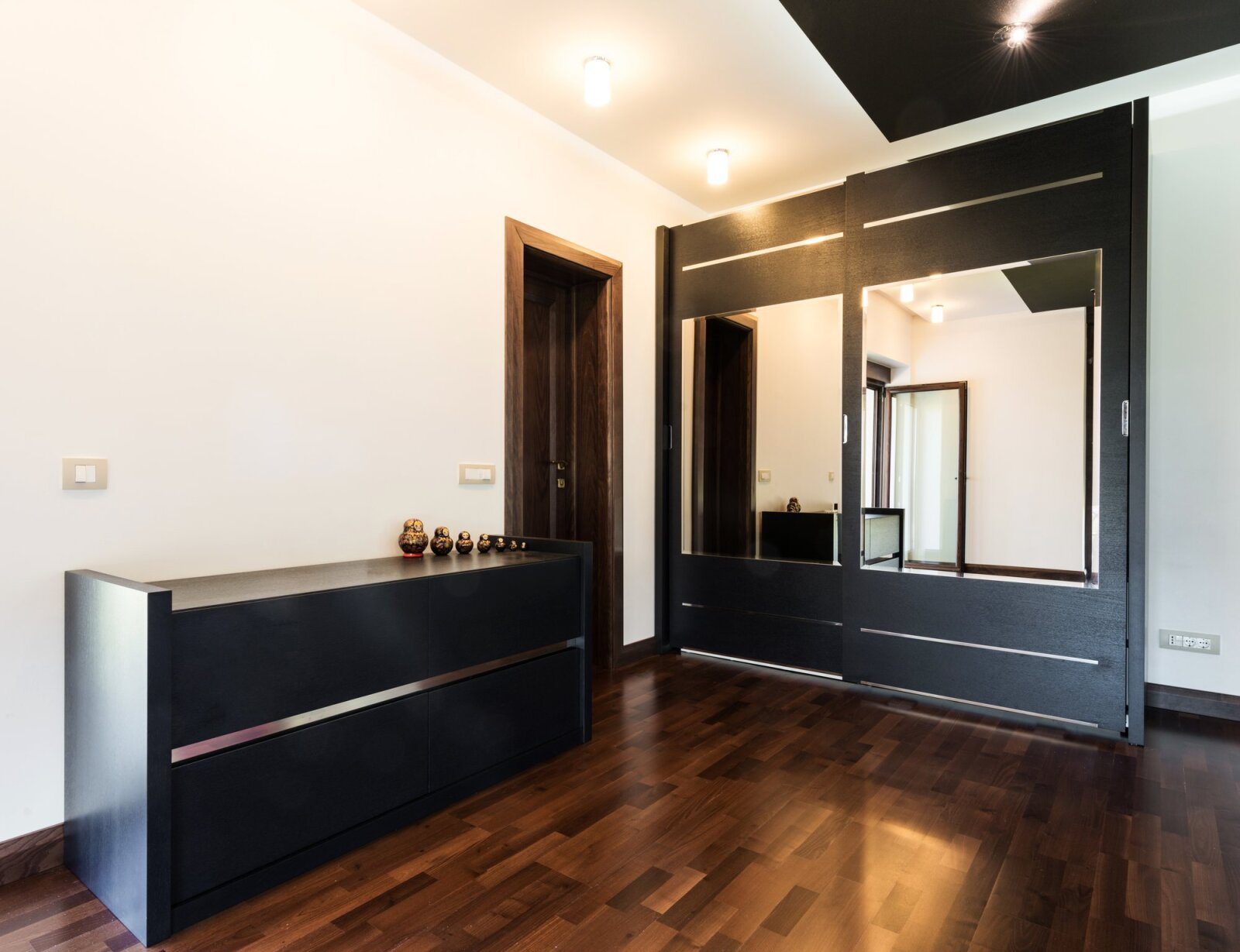 Puertas de armario con espejo y madera alrededor.