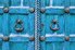 Pomos decorativos en una puerta azul.