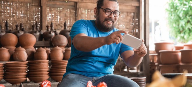 hombre tomando fotos de artesanías de cerámica