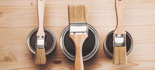 Pinceles en latas sobre madera