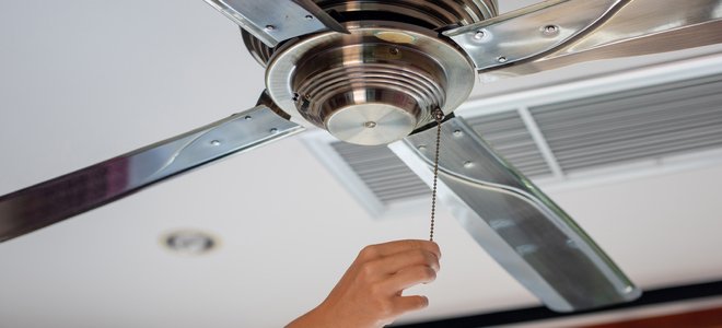 mano encendiendo el ventilador de techo