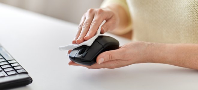 mujer, limpieza, ratón de la computadora, en el escritorio