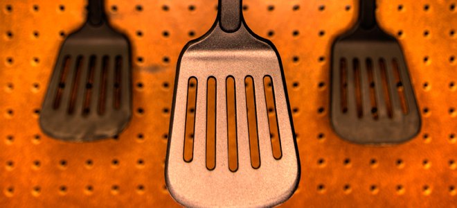 espátulas colgadas en una pared organizadora de tablero perforado