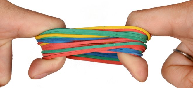 dedos estirando bandas de goma de colores