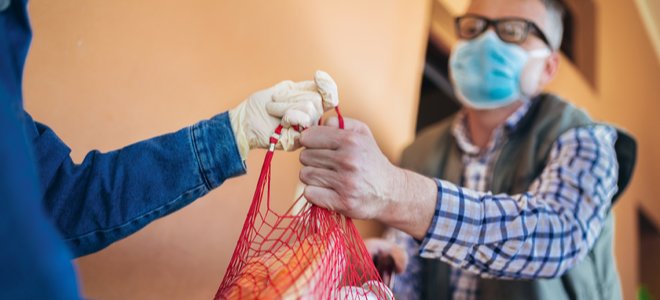 entregar comestibles a un amigo o vecino con guantes y mascarilla