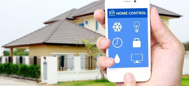 Una dama sosteniendo un teléfono inteligente frente a una casa.