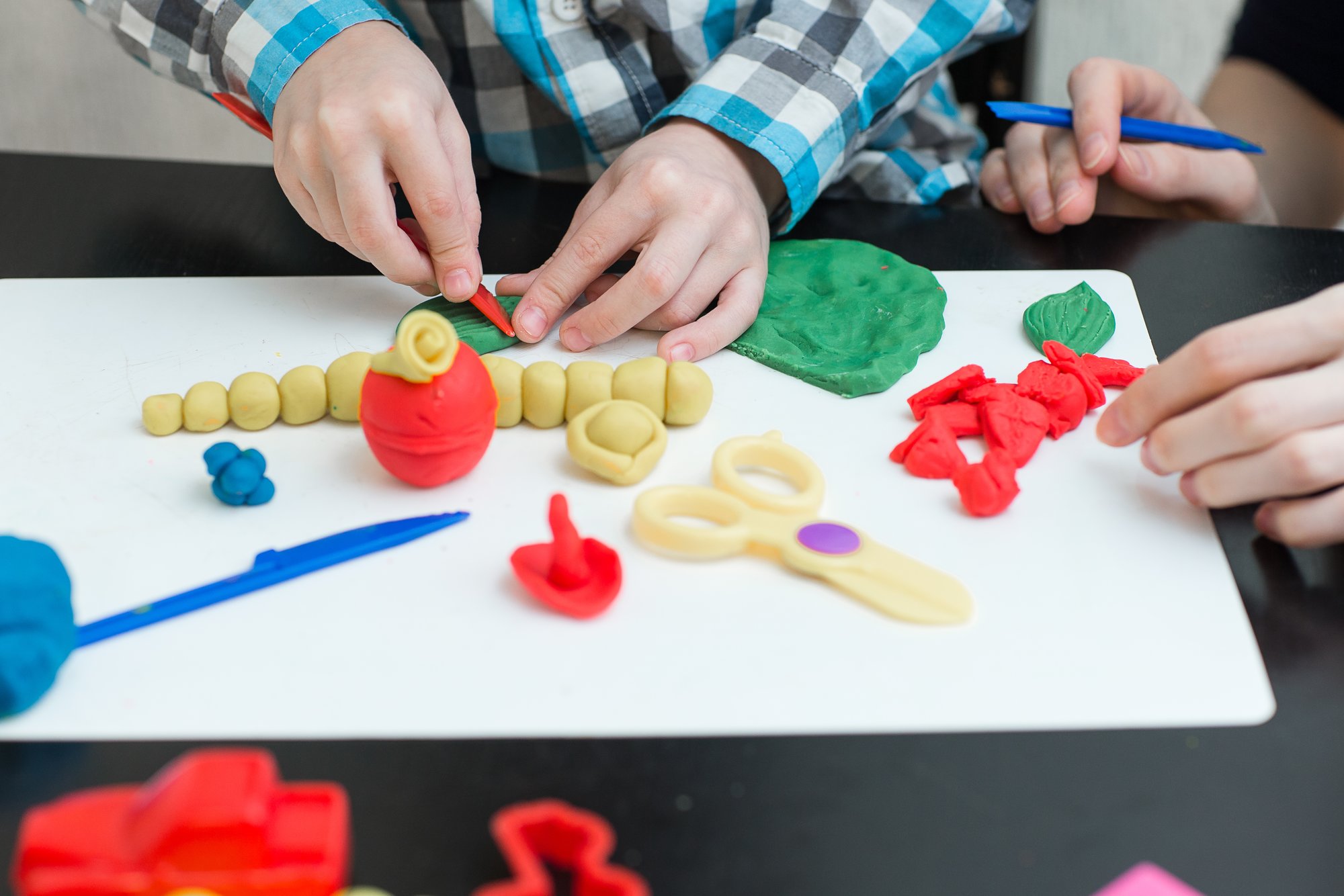 Un niño hace herramientas con plastilina.