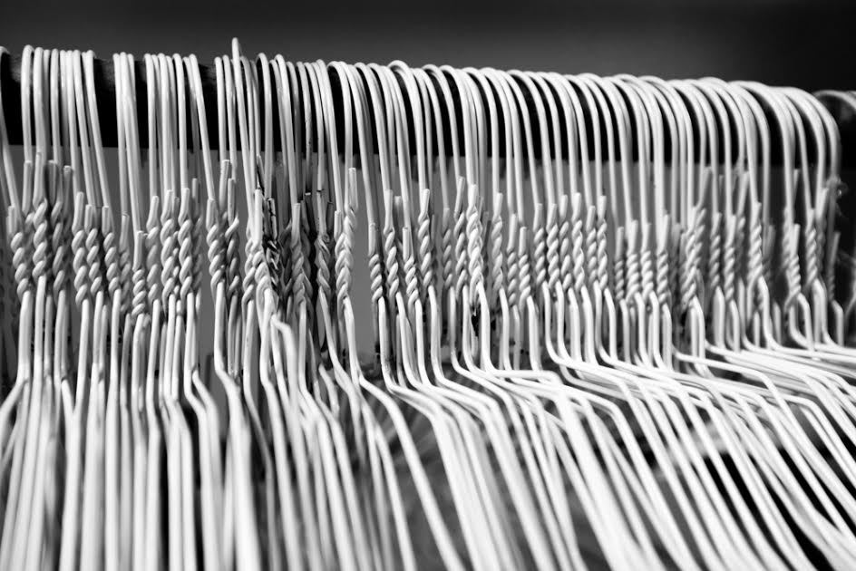 Una fila de perchas de alambre blanco. 