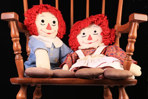 Raggedy Ann y Andy sentados en una mecedora.