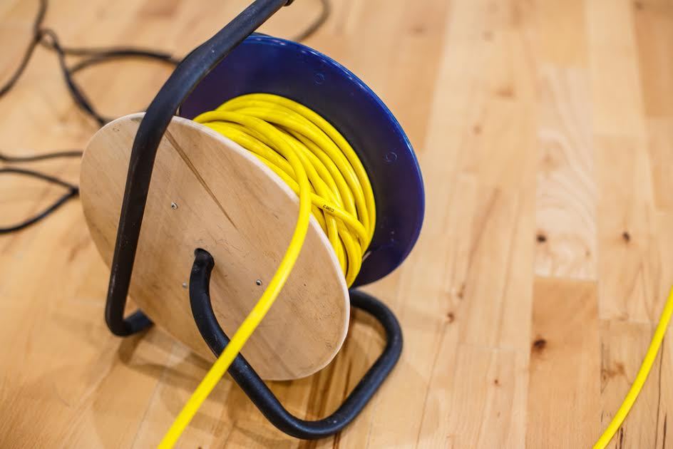 Un cable de extensión en un piso de madera.