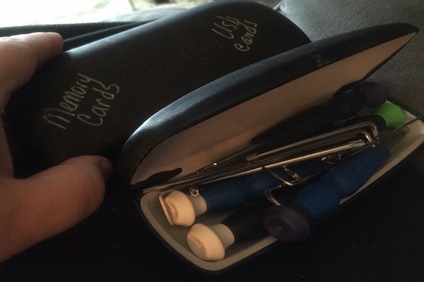 Porta gafas con pequeños objetos en su interior. 