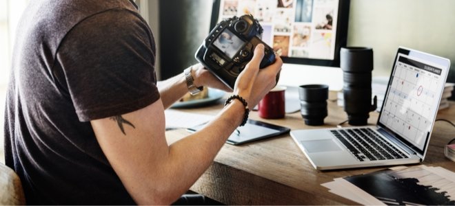 hombre con cámara y computadoras