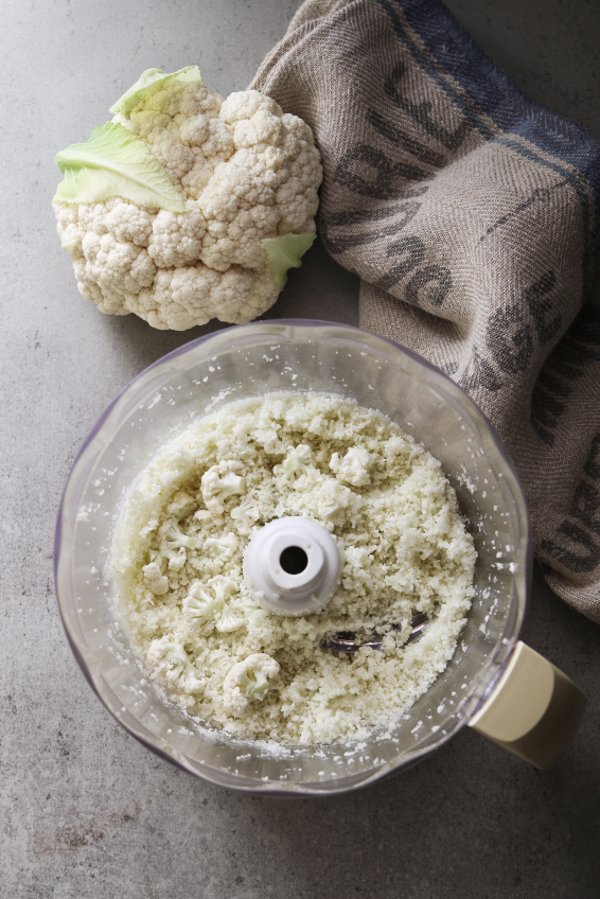 Un procesador de alimentos con una coliflor. 