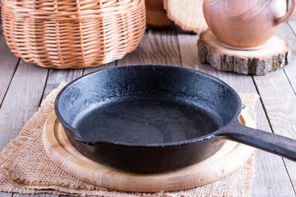 Una sartén de hierro fundido sobre la encimera de una cocina de campo. 