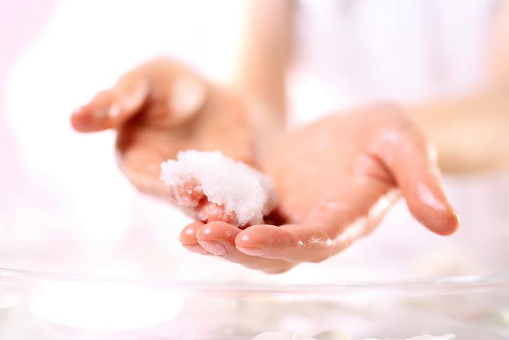 Un par de manos sosteniendo un exfoliante corporal. 