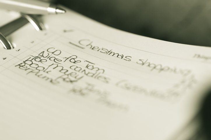 Una lista de compras en papel con un bolígrafo al lado. 