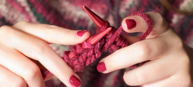 manos con esmalte de uñas tejer hilo rojo