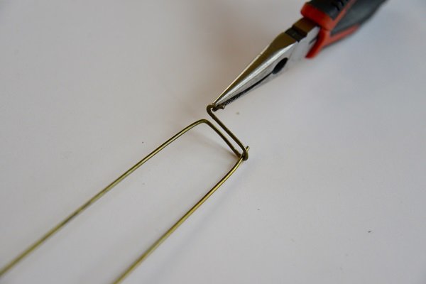 Doblar el imperdible con pinzas