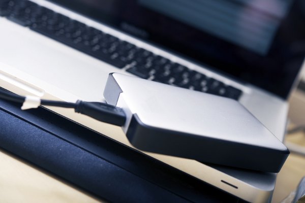 Un disco duro externo conectado a una computadora portátil. 