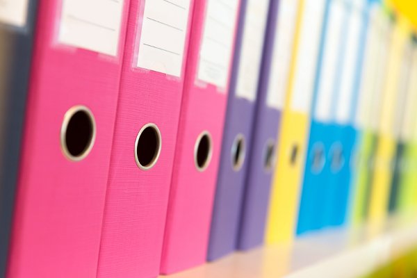 Una fila de carpetas de archivos de colores del arco iris. 