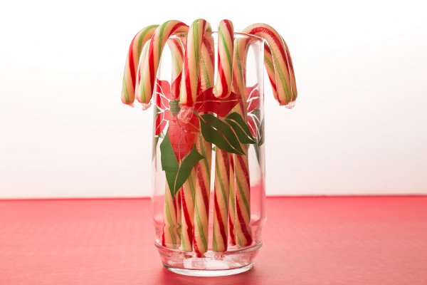 Una agrupación de bastones de caramelo en una copa de Navidad de cristal vintage. 