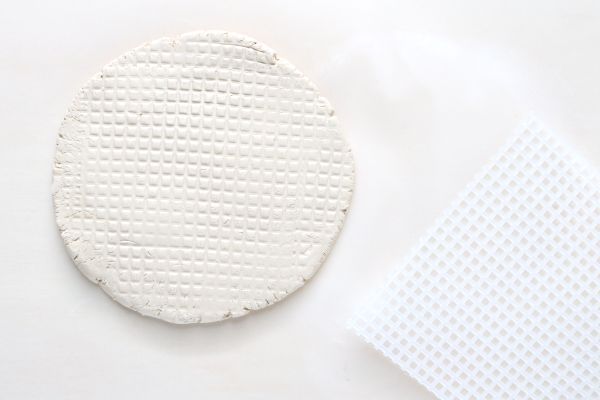 Una pieza de arcilla aplanada con una rejilla de plástico en la parte superior. 