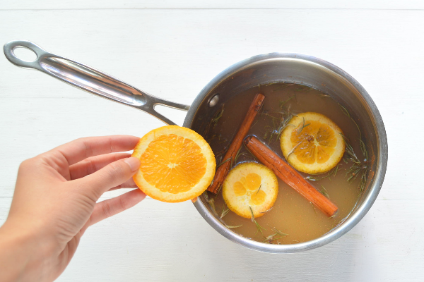 agregando rodajas de naranja al popurrí
