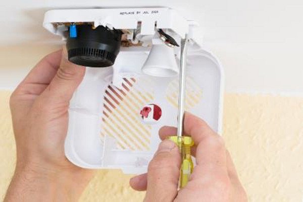 Comprobación de las baterías de una alarma de humo.