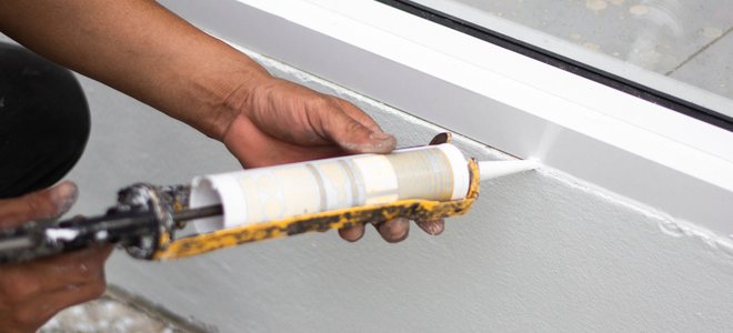 Una mano para calafatear una ventana