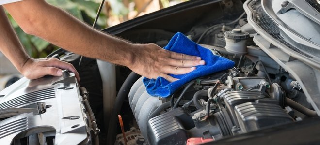 hombre limpiando un motor con un trapo