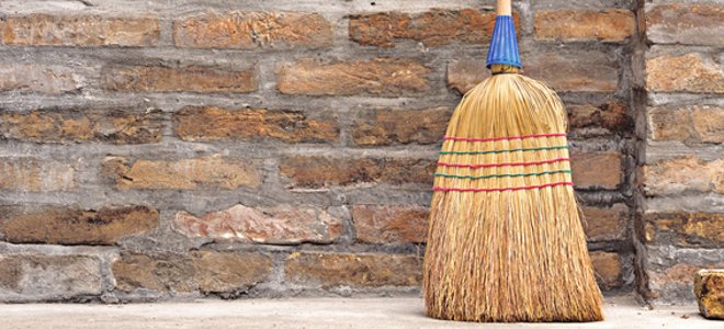 una escoba contra una pared de ladrillos
