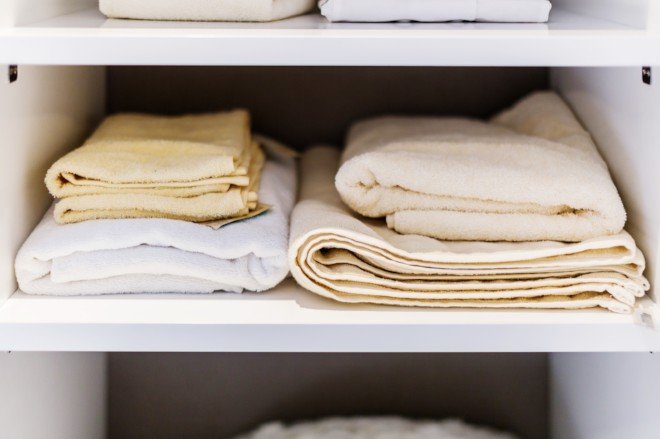 ropa de cama en un estante del armario