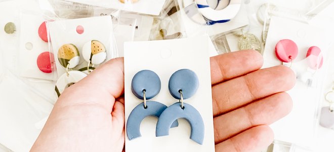 mano sosteniendo aretes hechos a mano