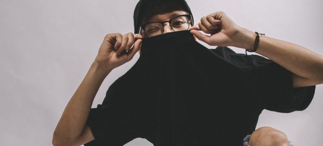 hombre sosteniendo su camiseta sobre su boca