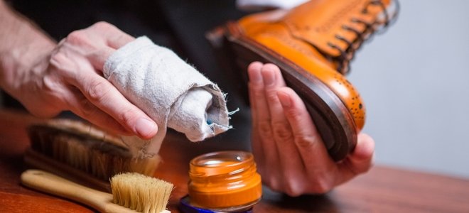 manos puliendo una bota