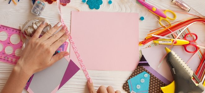 scrapbooking con materiales y una página rosa en blanco