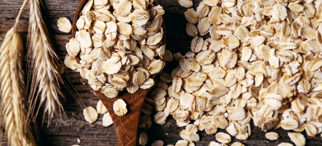 avena en una mesa de madera con una cuchara y trigo