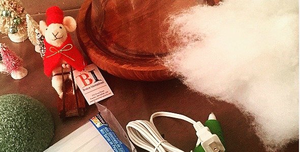 Suministros para el proyecto que incluyen una pistola de pegamento y un pequeño adorno de ratón.