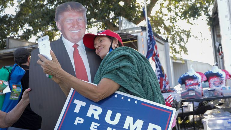 Una mujer se toma una foto con un cartel de Donald Trump en Orlando, Florida, este lunes.
